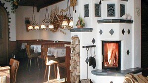 A cozy room with a fireplace, wooden furniture, and decorative elements like hanging lamps and wall sconces. - Vacation apartment no. 14 for 2 - 4 persons, approx. 100 m², 1 bedroom, living room, kitchen, bathroom (Bischofswiesen)