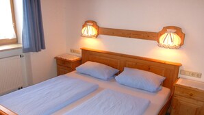 A double bed with two nightstands, each with a lamp. - Vacation apartment no. 18 for 2-4 persons, 50 m², 1 bedroom, 1 double bedroom, living room with kitchenette, bathroom (Bischofswiesen)