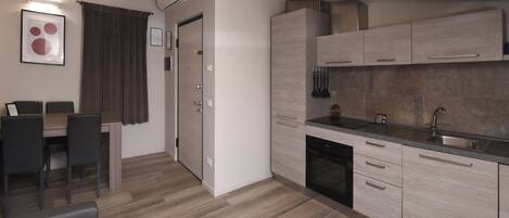Eine moderne Küche mit hellen Holzschränken, einem eingebauten Backofen und einer Edelstahl-Spüle.