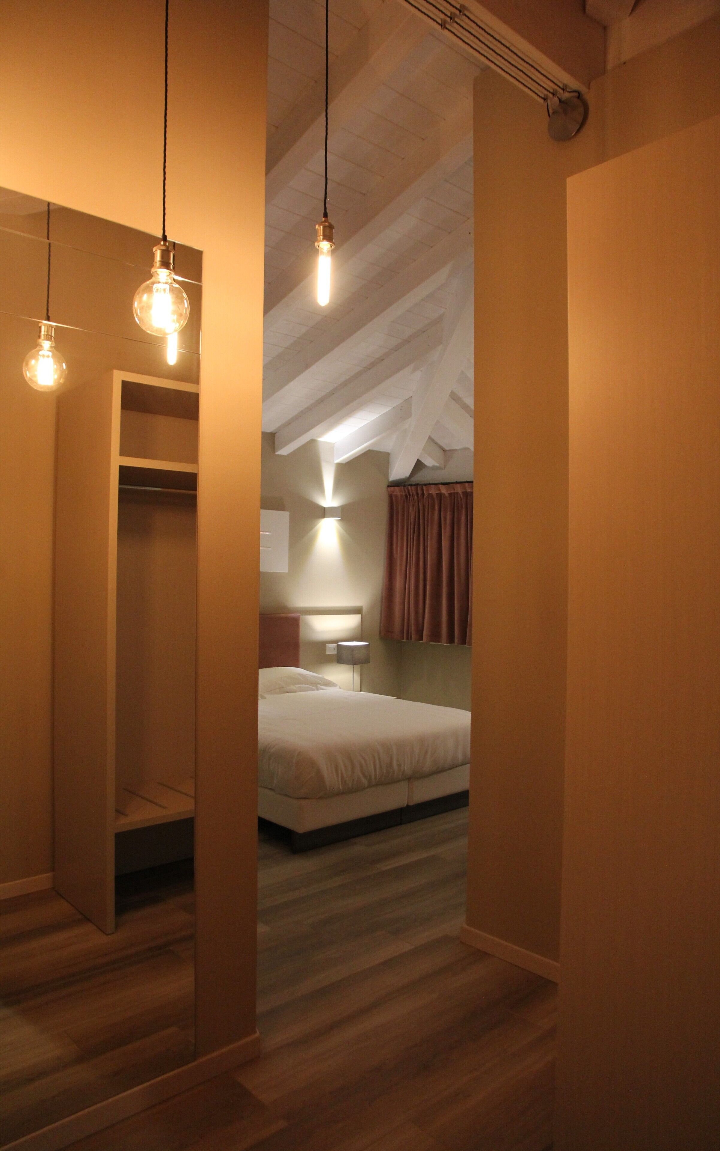 Een slaapkamer met een bed, nachtkastje en een kledingkast.