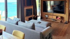 A room with a large TV, wooden ceiling, and a view of the sea. - Life Butiq Hotel (Bodrum)