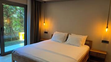 Quarto moderno com cama grande, mesas de cabeceira de madeira e iluminação ambiente.