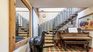 Un escalier avec une rampe en métal, un plancher en bois et un piano avec des partitions.