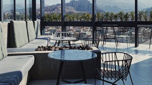 A rooftop terrace with seating, tables, and string lights. - MET Hotel (La Paz)