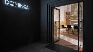 A modern hotel entrance with a glass door leading to a bar area. - MET Hotel (La Paz)