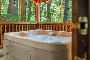 A hot tub with a wooden deck and a view of a forest. - Smoky Mountain Cabin w/ Sunrise Views • Hot Tub • Queen Bed (Sevierville)