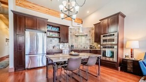 Una cocina moderna con armarios de madera oscura, electrodomésticos de acero inoxidable y una isla central con asientos.