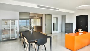 Eine moderne Küche mit Essbereich, einem großen Fenster und einer leuchtend orangefarbenen Akzentwand.