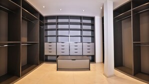 Ein moderner begehbarer Kleiderschrank mit zahlreichen Schubladen und Regalböden, der ein schlichtes Design und viel Stauraum bietet.