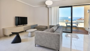 A modern living room with a flat-screen TV, a sofa, a coffee table, and a balcony with a view of the sea. - T2 sea view "Mare e Sole (Ajaccio)