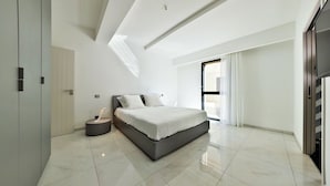 Een moderne slaapkamer met een groot bed, een nachtkastje en een kledingkast.