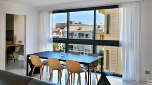 Een moderne eetruimte met een groot raam, een tafel en vier stoelen.