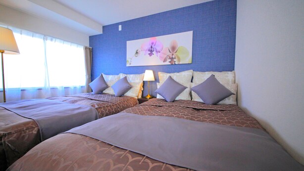 A hotel room with two beds, a nightstand, a lamp, and a wall-mounted artwork. - Roof Villa Shin-Imamiya (Osaka)