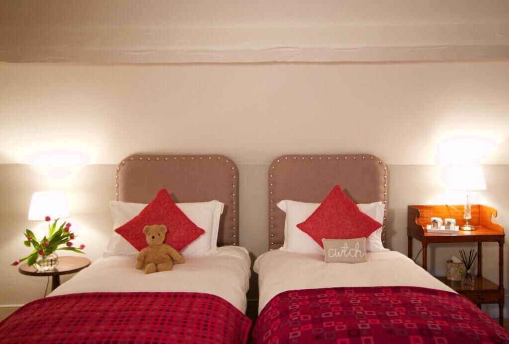 Hotellihuoneessa on kaksi sänkyä, joissa on punavalkoiset päiväpeitteet. Toisessa sängyssä on pehmolelu, ja toisessa sängyssä on tyyny, jossa lukee sana »sohva». Huoneessa on myös pieni pöytä, jossa on lamppu ja maljakko kukkia.