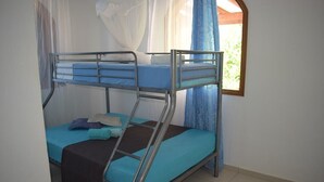 Quarto com beliche, janela, cortinas e mosquiteiro.
