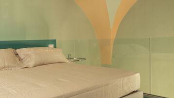 Un dormitorio con cama, mesita de noche y espejo en la pared.