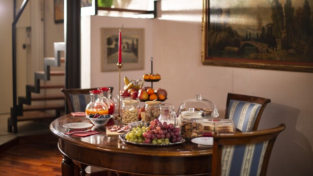 Un tavolo da pranzo con diversi cibi e una ciotola di frutta.