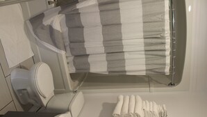 Un baño con inodoro, lavabo y cortina de ducha.