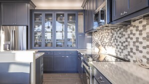 Une cuisine moderne avec des meubles bleus, un four à micro-ondes et un dosseret carrelé.