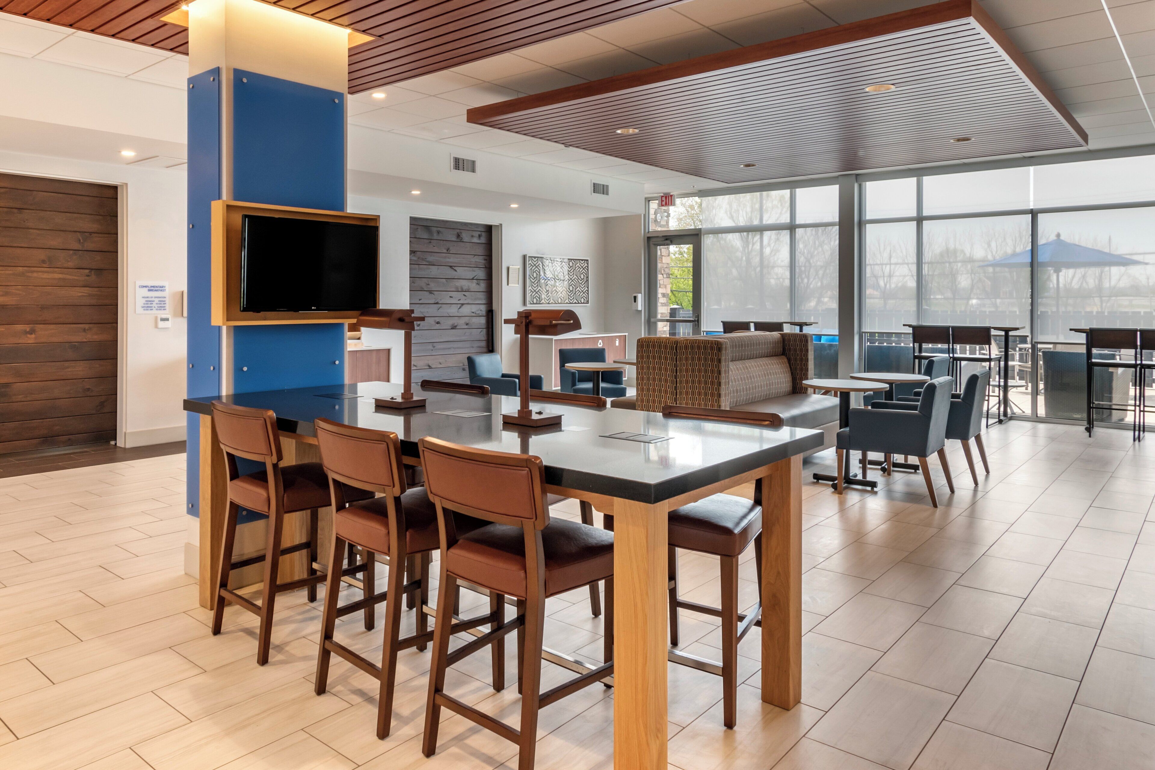 A modern interior with a bar area, seating, and a large window providing a view.