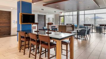 A modern interior with a bar area, seating, and a large window providing a view.