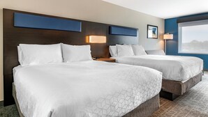 Een hotelkamer met twee bedden, een groot raam en uitzicht op buiten.