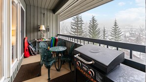 A balcony with a grill, chairs, and a table. - Snowloft Ski In & Ski out (Beaver Creek)