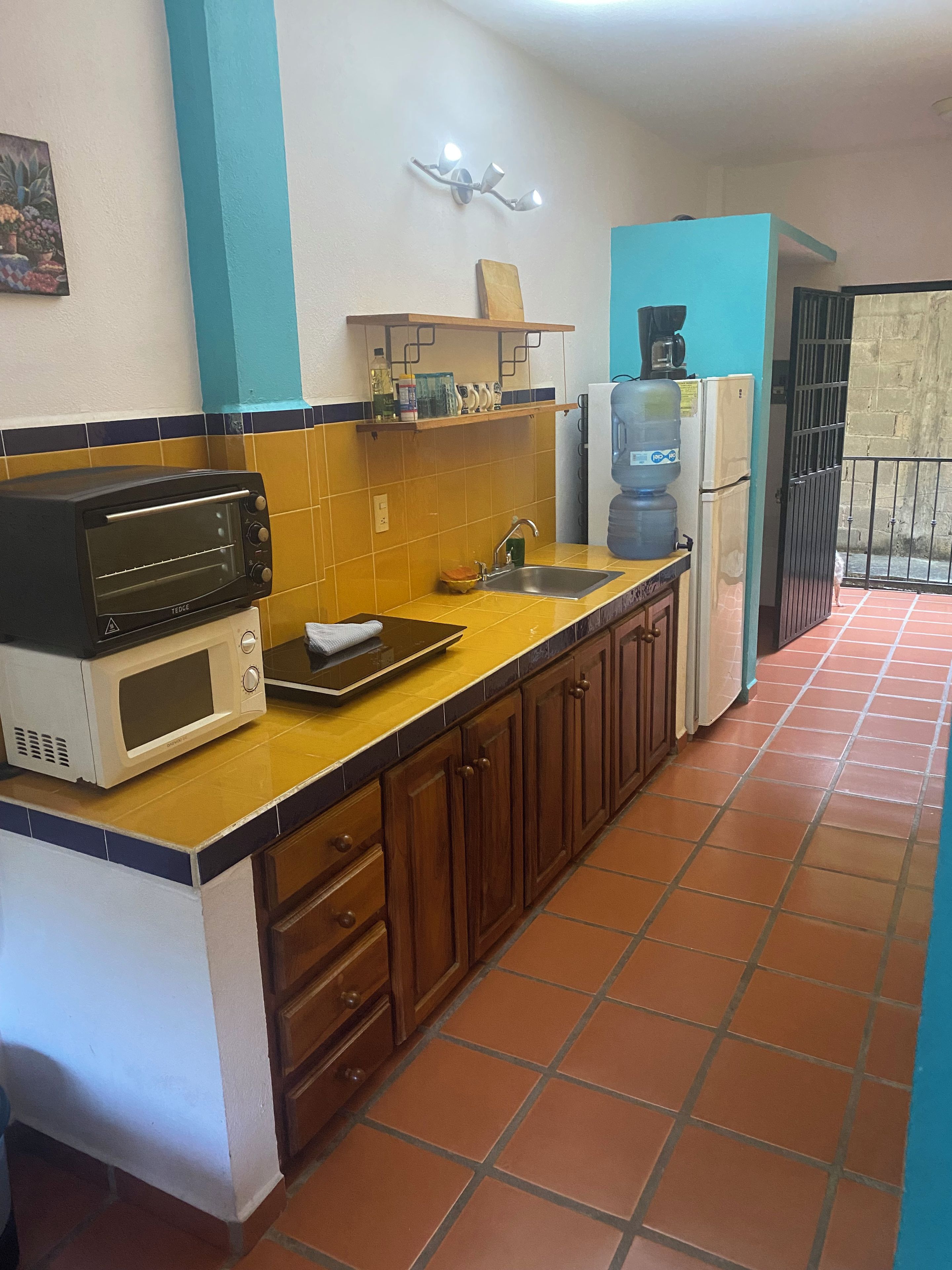 A kitchen with a microwave, toaster, sink, and cabinets.