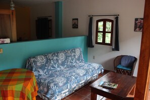 A living room with a sofa, a wooden table, and a chair.