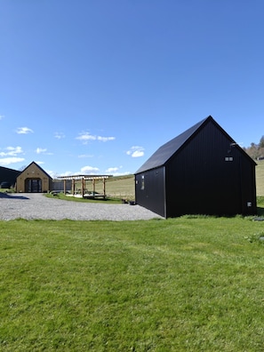 Ein Bauernhof und ein Holthaus mit einem Kiesweg davor.