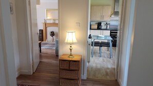 A hallway leading to a dining area with a table, chairs, and a lamp. - Newholme Self-catering Bungalow (Pitlochry)