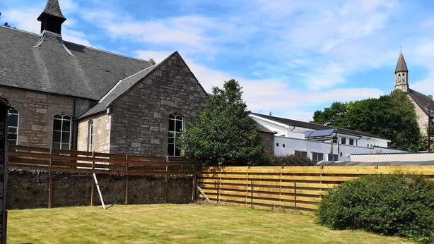 A stone building with a pitched roof and a small tower. - Newholme Self-catering Bungalow (Pitlochry)