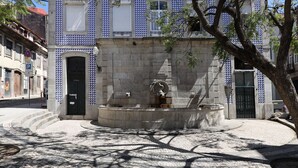 Une fontaine en pierre, ornée d’une statue au centre, entourée d’un pavage de pierres.