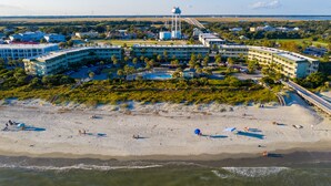 A large hotel with multiple buildings, a beach, and a water tower.