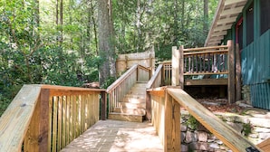 Un escalier en bois mène à un chalet entouré d’arbres.