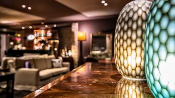 Un’area bar con un bancone in legno e vasi decorativi.