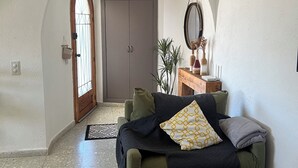 En hyggelig stue med en sofa, et sofabord og en dør til et andet rum.