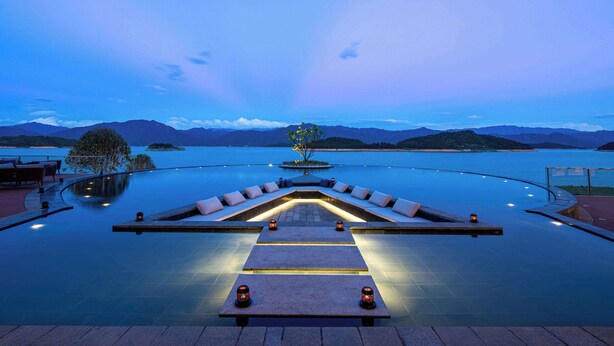 An infinity pool with a view of mountains and a lake at dusk. - Ramada by Wyndham Chenzhou Dongjiang Lake (Chenzhou)