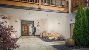 A modern building entrance with a stone pathway, a wooden balcony, and a sign for 'REGENSEE'. - Wohnung 3 in Luxury Apartments "R6 Tegernsee" (Bad Wiessee)