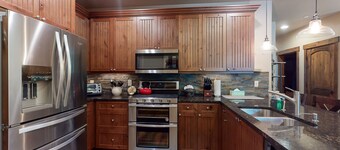 Sunny riverfront getaway with mountain views, private hot tub, & large patio