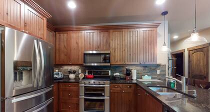 Sunny riverfront getaway with mountain views, private hot tub, & large patio