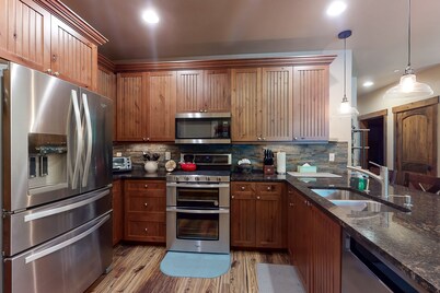 Sunny riverfront getaway with mountain views, private hot tub, & large patio