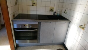 Una cocina con horno empotrado y un lavabo.