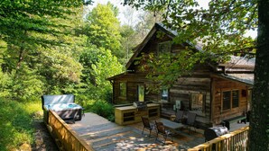 A cabin with a deck, outdoor seating, and a hot tub. - Rest and rejuvenate in seclusion at Nature's Nest! (Nashville)