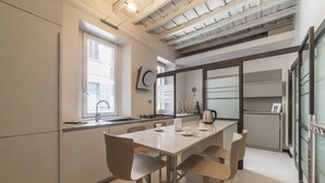Una cocina moderna con comedor, que cuenta con un amplio ventanal, horno empotrado y cafetera.