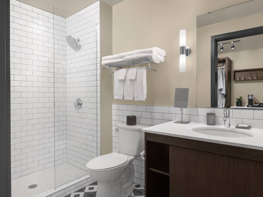 A modern bathroom with a shower, toilet, sink, and vanity.