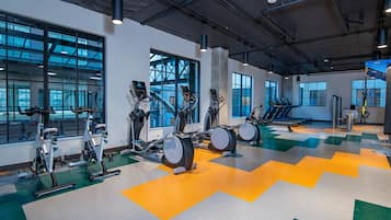 Un gimnasio con bicicletas estáticas, elípticas y cintas de correr.