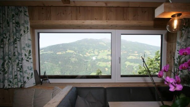 Una habitación con un ventanal amplio que ofrece vistas a un paisaje montañoso.