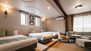 A hotel room with two beds, a sofa, a small table, and a chair. There are wall-mounted lights and a window with curtains. - Grand Base Hakata-Ⅰ (Fukuoka)