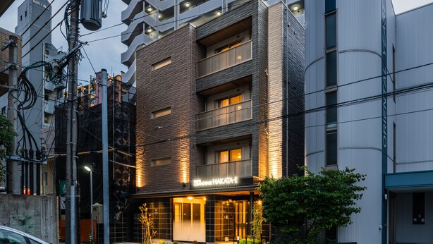 A multi-story building with a modern facade, featuring a prominent entrance with illuminated signage. - Grand Base Hakata-Ⅰ (Fukuoka)